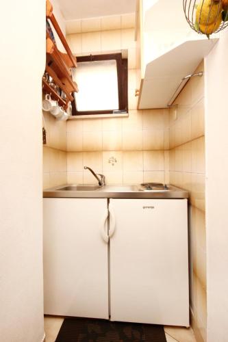 a small kitchen with a sink and a window at Apartments and rooms by the sea Racisce, Korcula - 4341 in Račišće