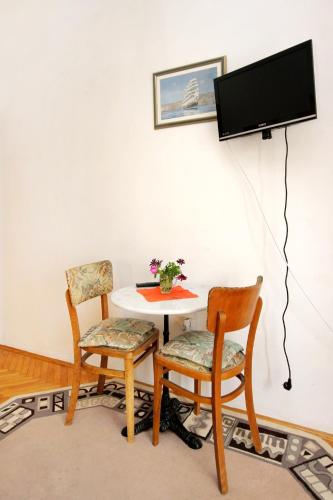 a room with a table and two chairs and a tv at Apartments and rooms by the sea Racisce, Korcula - 4341 in Račišće