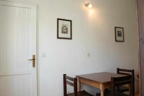 une table à manger avec deux chaises et un mur blanc dans l'établissement Studio Korcula 4356a, à Korčula