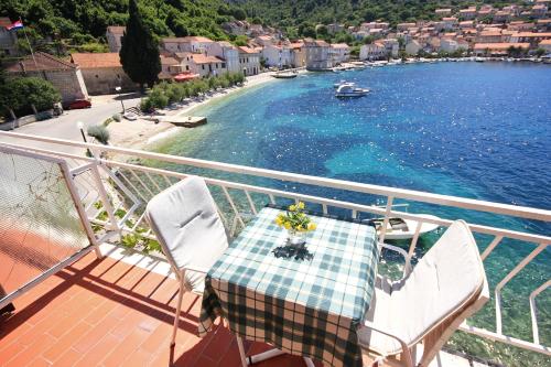 a balcony with a table and chairs and the water at Double Room Racisce 4341a in Račišće