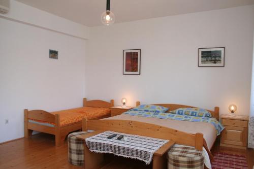 Apartments and rooms by the sea Korcula - 4356 في كورتْشولا: غرفة نوم بها سريرين وطاولة