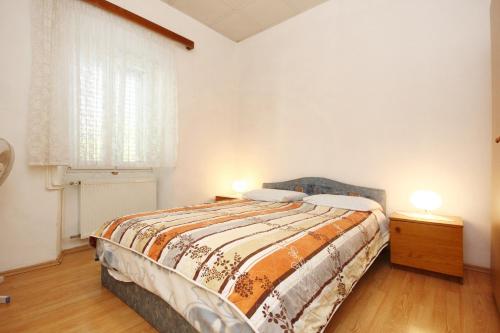 a bedroom with a bed and a window and two lamps at Double Room Lumbarda 4436a in Lumbarda