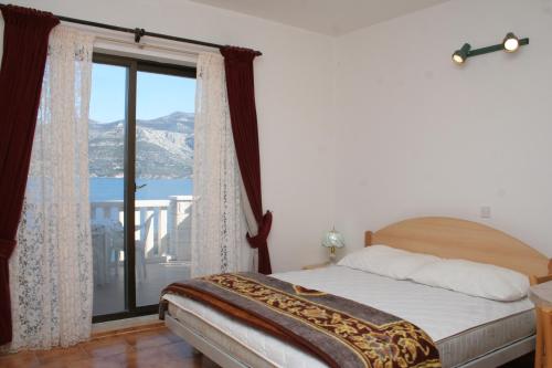 sypialnia z łóżkiem i dużym oknem w obiekcie Apartments by the sea Tri Zala, Korcula - 4351 w Korčuli
