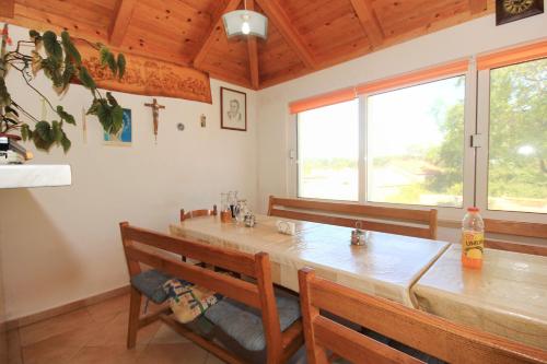 a dining room with a large wooden table and benches at Double Room Lumbarda 4436d in Lumbarda