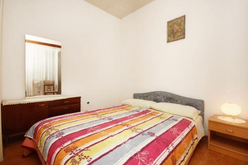 a bedroom with a bed and a mirror and a window at Double Room Lumbarda 4436d in Lumbarda
