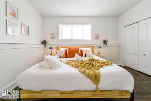 a bedroom with a large white bed with gold decorations at Tropical Oasis - King Beds - Free Netflix & Parking - Fast Wi-Fi in Edmonton
