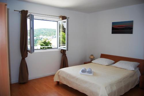 1 dormitorio con cama y ventana grande en Apartments with a parking space Zavalatica, Korcula - 4420 en Zavalatica