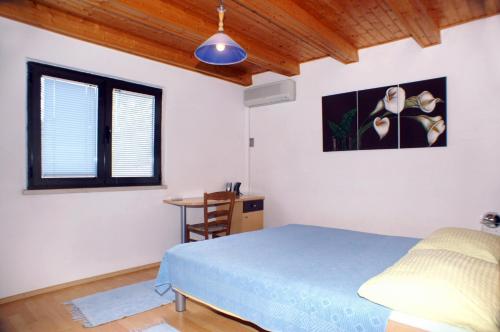 a bedroom with a blue bed and a window at Seaside apartments with a swimming pool Lumbarda, Korcula - 4404 in Lumbarda