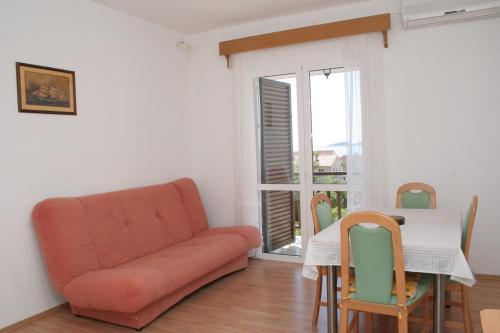 uma sala de estar com um sofá e uma mesa com cadeiras em Apartment Orebic 4494d em Orebić