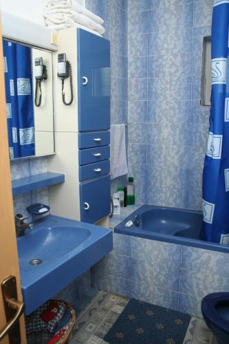 a blue bathroom with a tub and a sink at Rooms by the sea Vrboska (Hvar) - 4600 in Vrboska