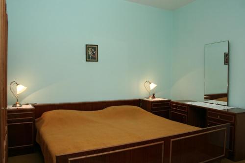 Rooms by the sea Vrboska (Hvar) - 4600 في فربوسكا: غرفة نوم بسرير مع مصباحين ومرآة