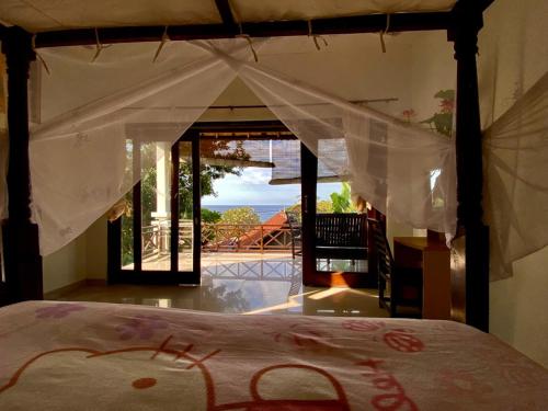 Schlafzimmer mit einem Bett und Blick auf ein Haus in der Unterkunft sriganesh in Ambat