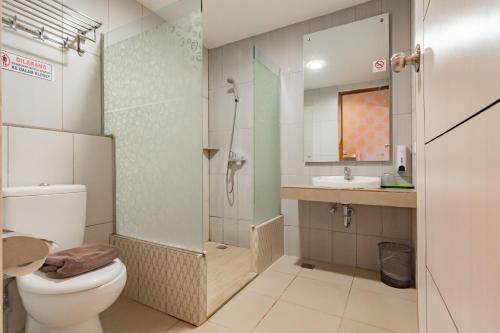 ein Bad mit einer Dusche, einem WC und einem Waschbecken in der Unterkunft RedDoorz Premium near Bandung Station in Bandung