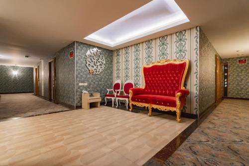 a room with a red chair and two chairs at RedDoorz Premium near Bandung Station in Bandung