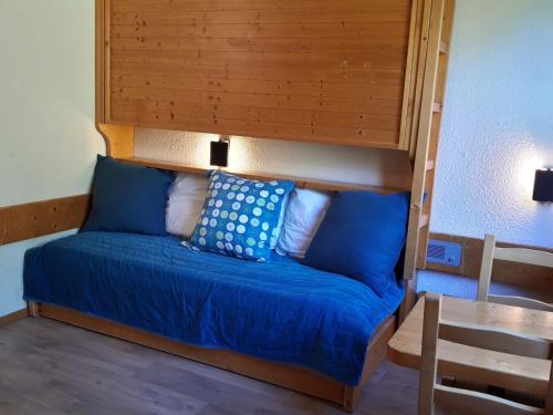 łóżko z niebieską pościelą i poduszkami w pokoju w obiekcie Studette cosy pour 2 pers. - Centre station Arc 1800 - Ski aux pieds - Wifi gratuit - FR-1-346-511 w mieście Arc 1800