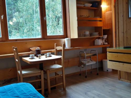 - une petite table et des chaises dans une chambre avec fenêtres dans l'établissement Studette cosy pour 2 pers. - Centre station Arc 1800 - Ski aux pieds - Wifi gratuit - FR-1-346-511, à Arc 1800