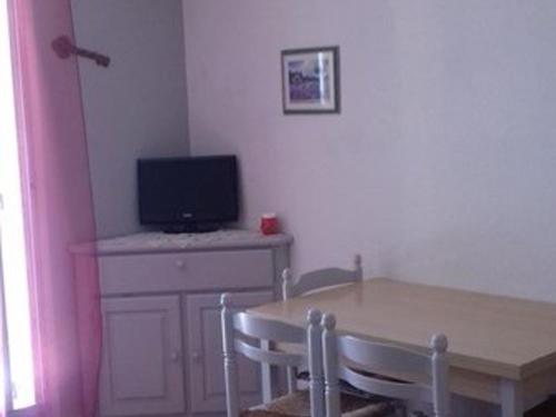 une salle à manger avec une table et une télévision sur un bureau dans l'établissement Charmant studio climatisé en rez-de-jardin, proche plage, avec garage privé à Cavalaire-sur-Mer - FR-1-226B-116, à Cavalaire-sur-Mer