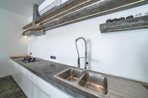 una cocina con fregadero y estufa en Loft Charly - Contemporary 1-bdr luxury loft in GREAT LOCATION, en Canggu