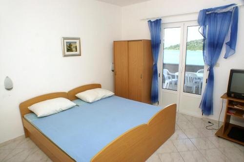 a bedroom with a bed and a television and a balcony at Apartments by the sea Luka Dubrava, Peljesac - 4568 in Janjina