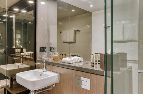 布里斯本的住宿－The Point Brisbane Hotel，一间带水槽和镜子的浴室