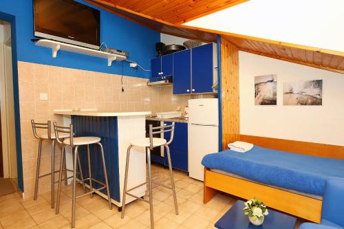 拉希什切的住宿－Apartments by the sea Racisce, Korcula - 4360，一间拥有蓝色墙壁和凳子的小厨房