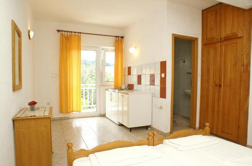 a room with a kitchen with a bed and a refrigerator at Studio Zuljana 4576a in Žuljana