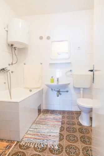 a white bathroom with a sink and a toilet at Seaside holiday house Cove Zarace - Gdinj, Hvar - 4603 in Gdinj