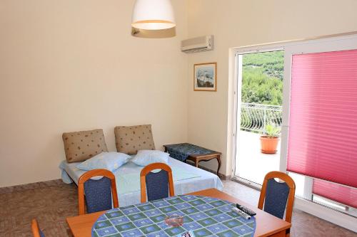 a bedroom with a bed and a table and a window at Family friendly seaside apartments Cove Jagodna - Brusje, Hvar - 4606 in Brusje