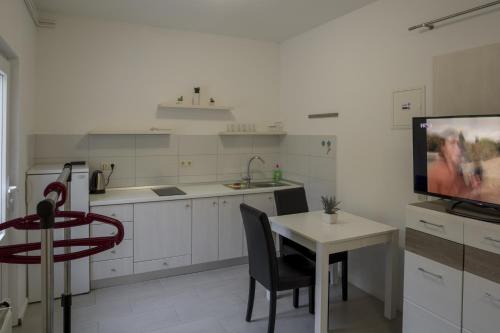 a kitchen with a table and a tv in it at Studio Zuljana 4573b in Žuljana