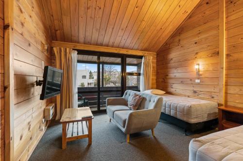 una camera con letto e TV di Aspiring Lodge Motel a Wanaka