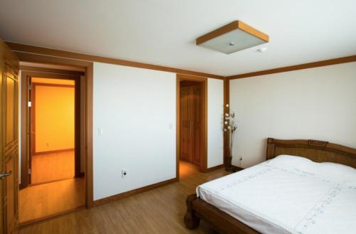 - une chambre avec un lit et un plafond dans l'établissement Seaspovill Resort, à Samcheok