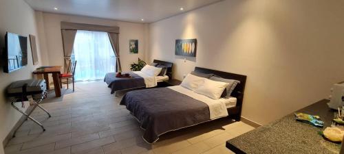 a hotel room with two beds and a table at LOP Inn San Jose Aeropuerto - Costa Rica in Ciudad Cariari