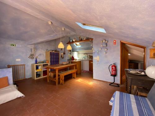 Casa do Búzio Cosy Apartment next to the Beach في لورينها: غرفة معيشة مع طاولة ومطبخ