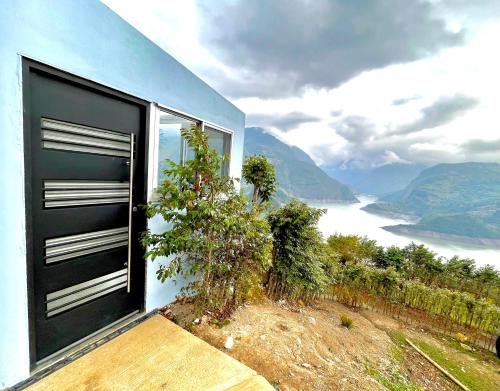 a blue house with a black door and a view at La Vista EcoHouse in Macanal