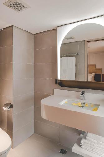 a bathroom with a sink and a mirror at Hanoi Le Jardin Hotel & Spa in Hanoi