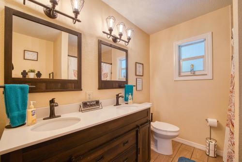 a bathroom with a sink and a toilet and a mirror at Large Tampa Home*Sleeps 16*Near Busch Gardens &USF in Tampa