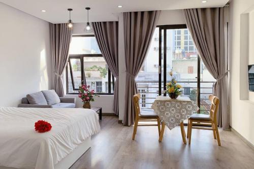 a hotel room with a bed and a table and chairs at POOL Seaview 3A - Deluxe Apartment BALCONY in Da Nang