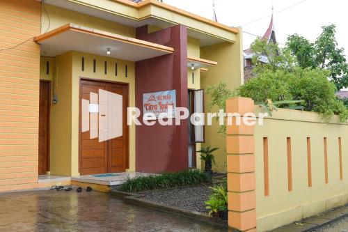 une maison avec un panneau sur sa porte dans l'établissement Homestay Rumah Citra Indah Syariah Mitra RedDoorz, à Bukittinggi