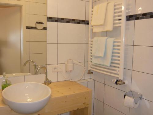 a white bathroom with a sink and a mirror at Joe's Apartments in Bad Liebenzell