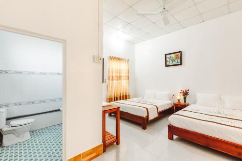 a hotel room with two beds and a bathroom at Ngoc Qui Bungalow in Phu Quoc