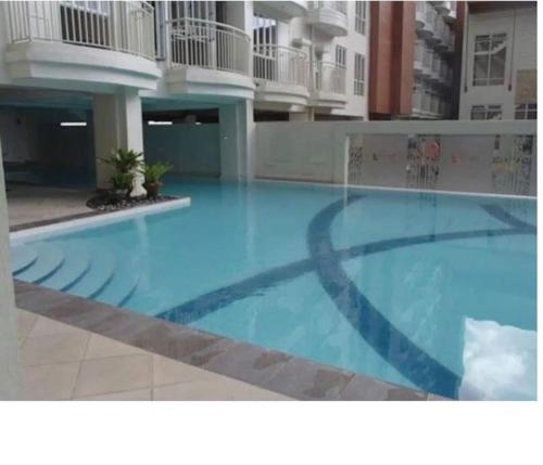 a large blue swimming pool in a building at 2BR Condo in Tagaytay I Lake View I Fast Wifi I Free Parking in Tagaytay