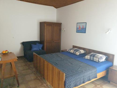 a bedroom with a bed and a chair at Apartments by the sea Dingac - Potocine, Peljesac - 4533 in Potomje
