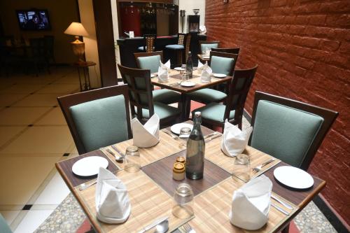 een restaurant met een tafel en stoelen en een fles wijn bij The Richmond in Pondicherry