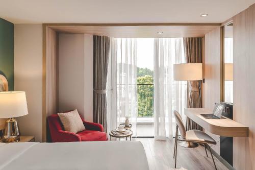 a hotel room with a bed and a desk and a window at Hanoi Le Jardin Hotel & Spa in Hanoi