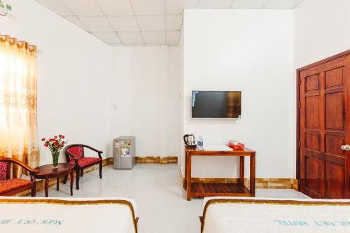 a waiting room with a table and chairs and a tv at Ngoc Qui Bungalow in Phu Quoc