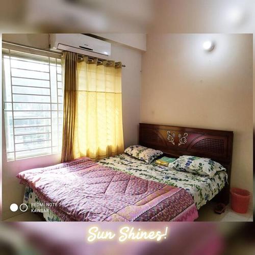 ein Schlafzimmer mit einem Bett und einem Fenster mit einer Tagesdecke in der Unterkunft DAC Peaceful AC King Bed WIFI & 24hr Security in Dhaka