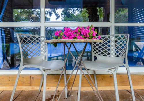 two chairs and a table with pink flowers on it at Sara Resort in Koh Rong Sanloem