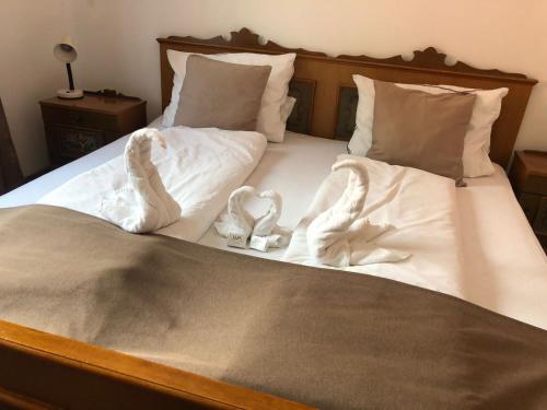 a bed with two white socks and two hearts at Gasthaus Casa Kugler in Anina