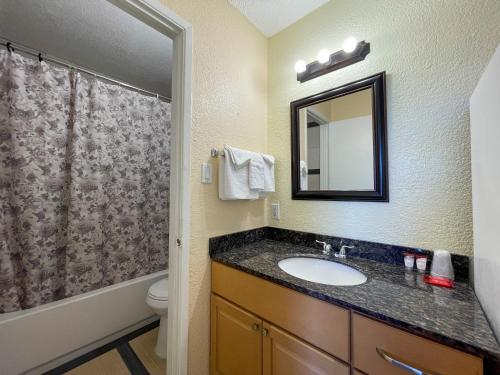 bagno con lavandino, servizi igienici e specchio di Motel 7 - Near Six Flags, Vallejo - Napa Valley a Vallejo