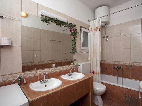 uma casa de banho com 2 lavatórios, um WC e um espelho. em Apartments with a parking space Zuljana, Peljesac - 4573 em Zuljana